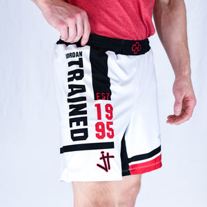 Side View of model wearing white, black, and red Jordan Trained Elite Wrestling Shorts. Established 1995