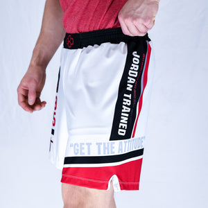Side View of model wearing white, black, and red Jordan Trained Elite Wrestling Shorts. 